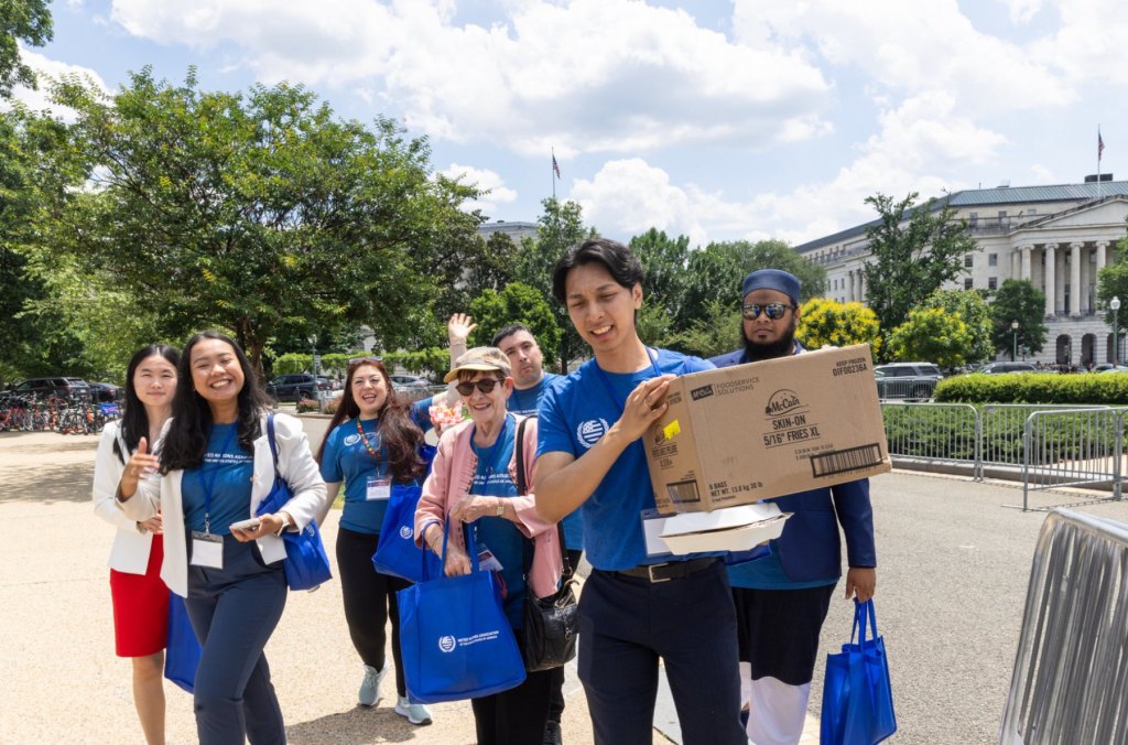 Volunteers in blue shirts carrying supplies