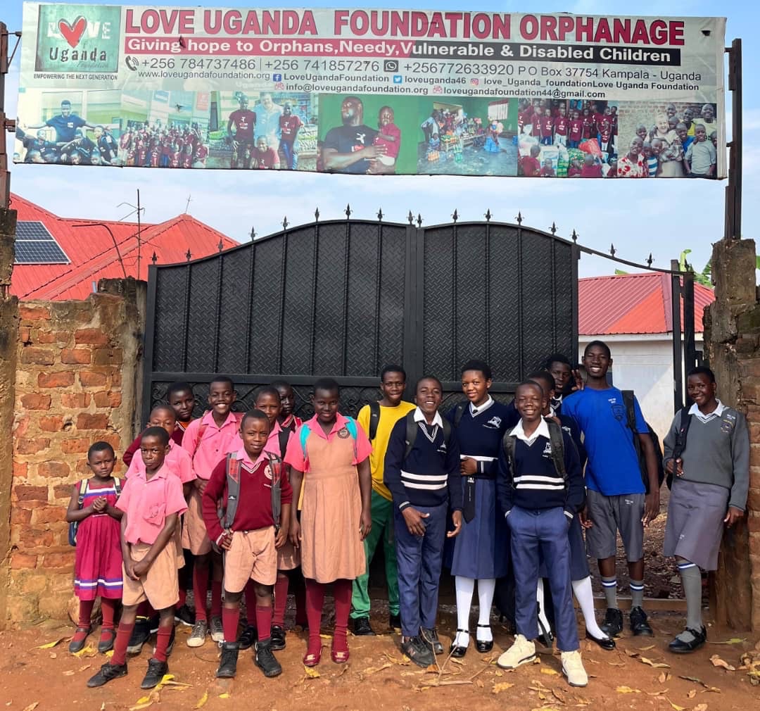 Children and staff of the Love Uganda Foundation standing in front of the orphanage gate in Kampala