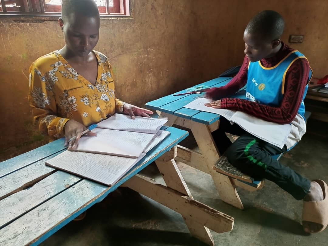 Two children at the Love Uganda Foundation studying at wooden desks